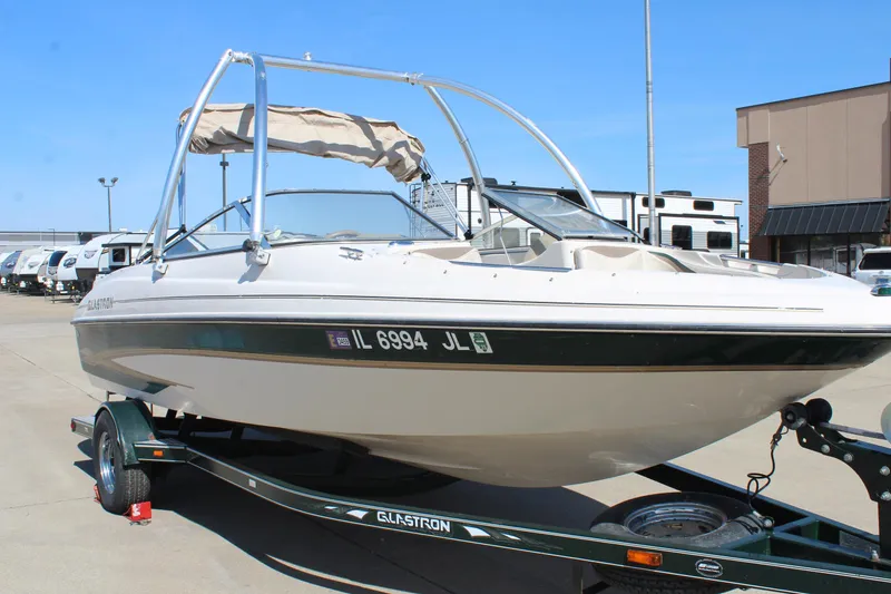 Slide: The Image of 2001 Glastron GX 185 boat on trailer, parked outdoors, with a blue sky background. - 1