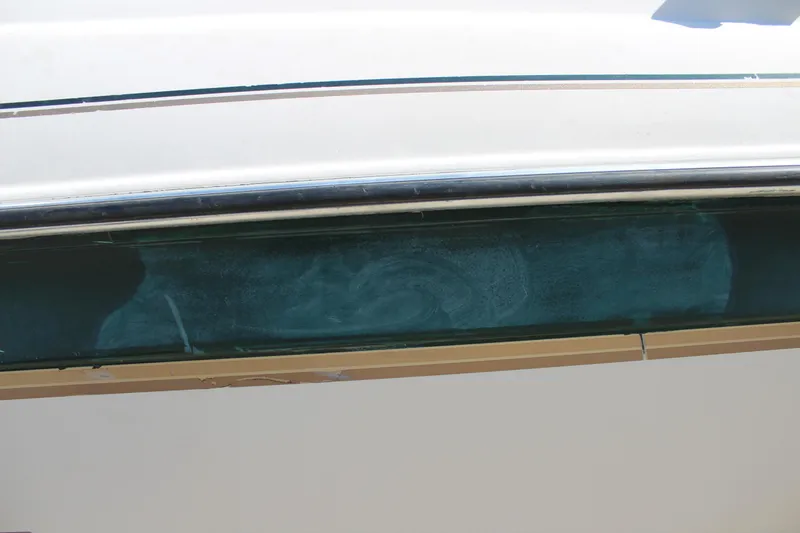 Slide: The Image of 2001 Glastron GX 185 boat side view with blue and white detailing. - 8