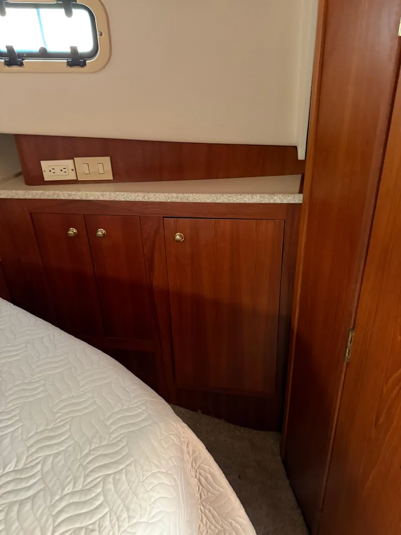 Slide: The Image of 2000 Mainship 390 Trawler cabin interior with wood cabinetry and bed. - 11