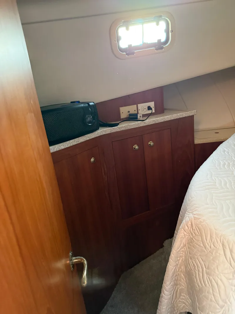 Slide: The Image of 2000 Mainship 390 Trawler cabin interior with wooden cabinetry and bed. - 12
