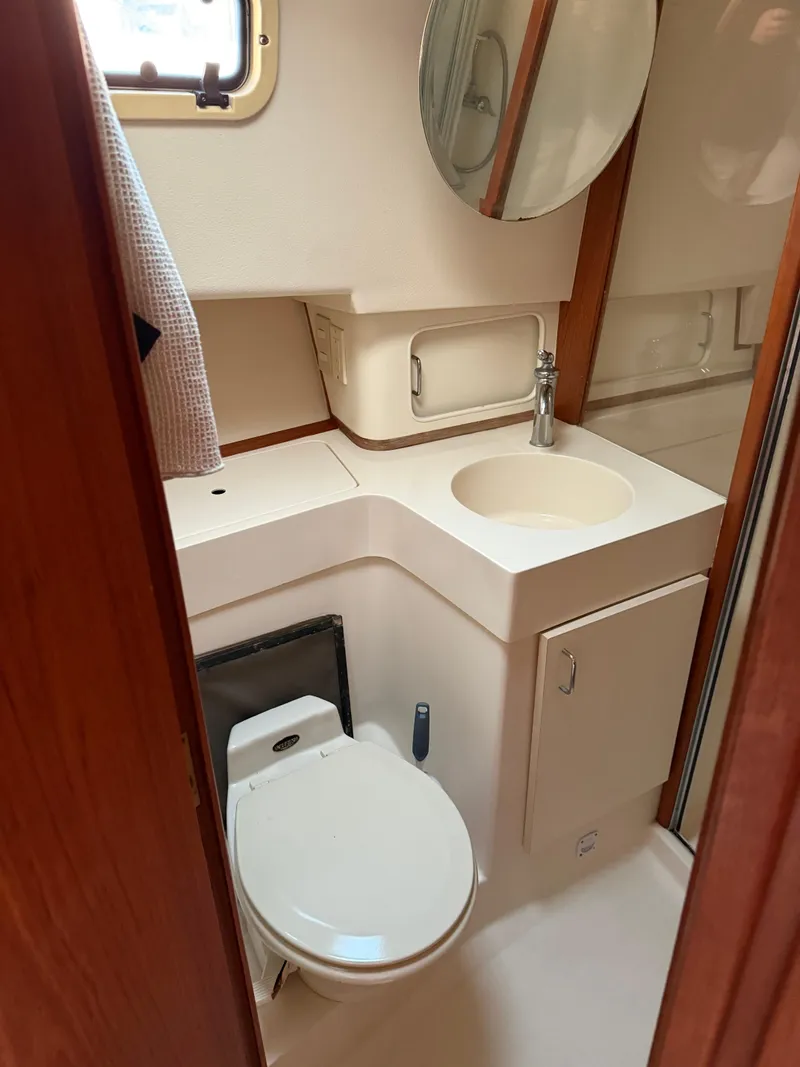 Slide: The Image of 2000 Mainship 390 Trawler bathroom with toilet, sink, and mirror. - 13