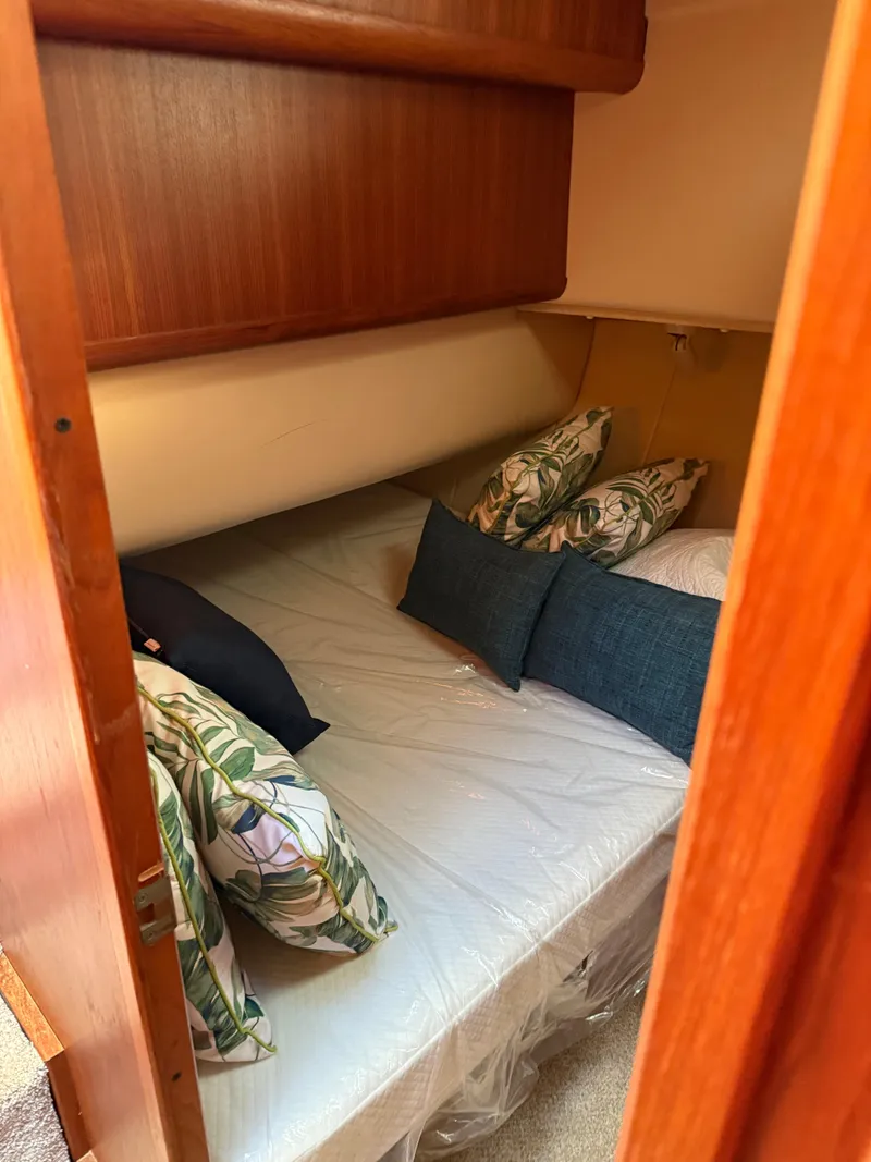 Slide: The Image of Cozy cabin interior of 2000 Mainship 390 Trawler with plush bedding and decorative pillows. - 14