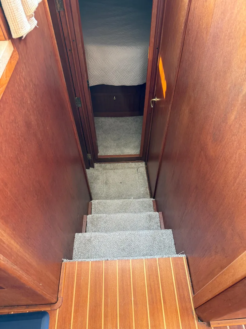 Slide: The Image of Staircase inside 2000 Mainship 390 Trawler, leading to a cozy cabin area. - 15