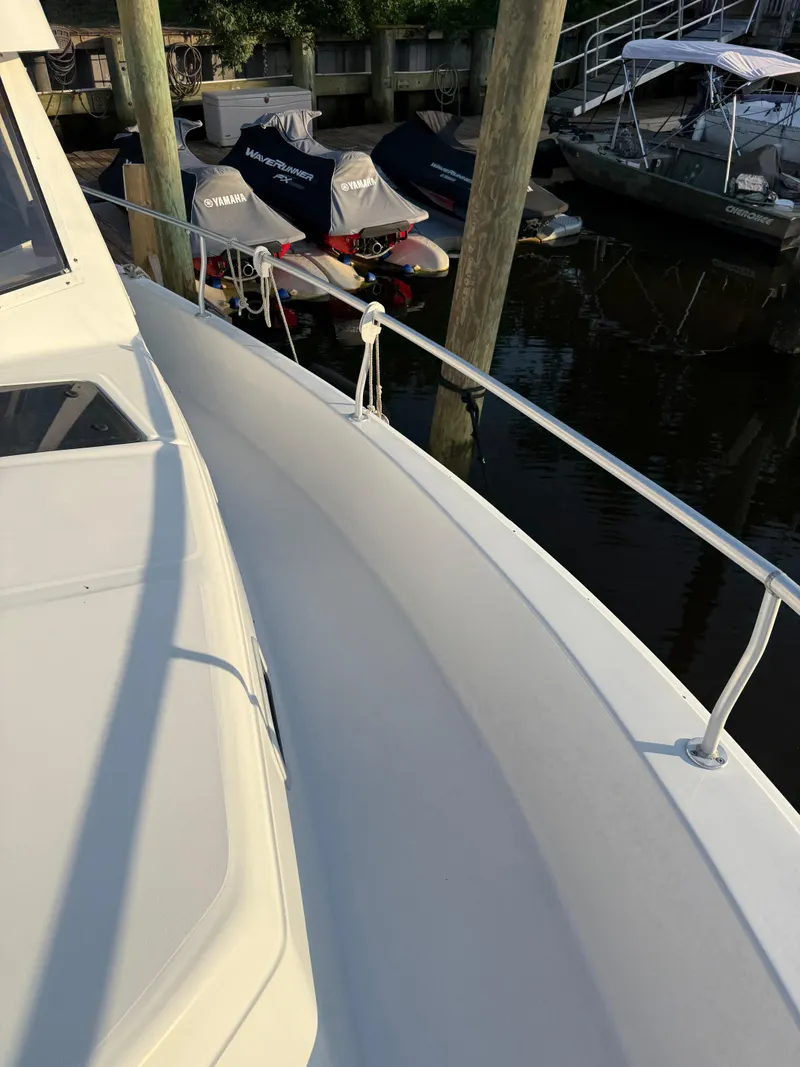 Slide: The Image of 2000 Mainship 390 Trawler docked, showcasing sleek deck and railing design. - 21