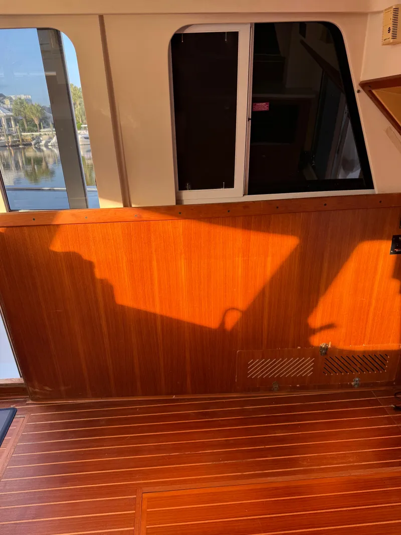 Slide: The Image of Interior of 2000 Mainship 390 Trawler with wooden paneling and sunlight streaming through windows. - 7