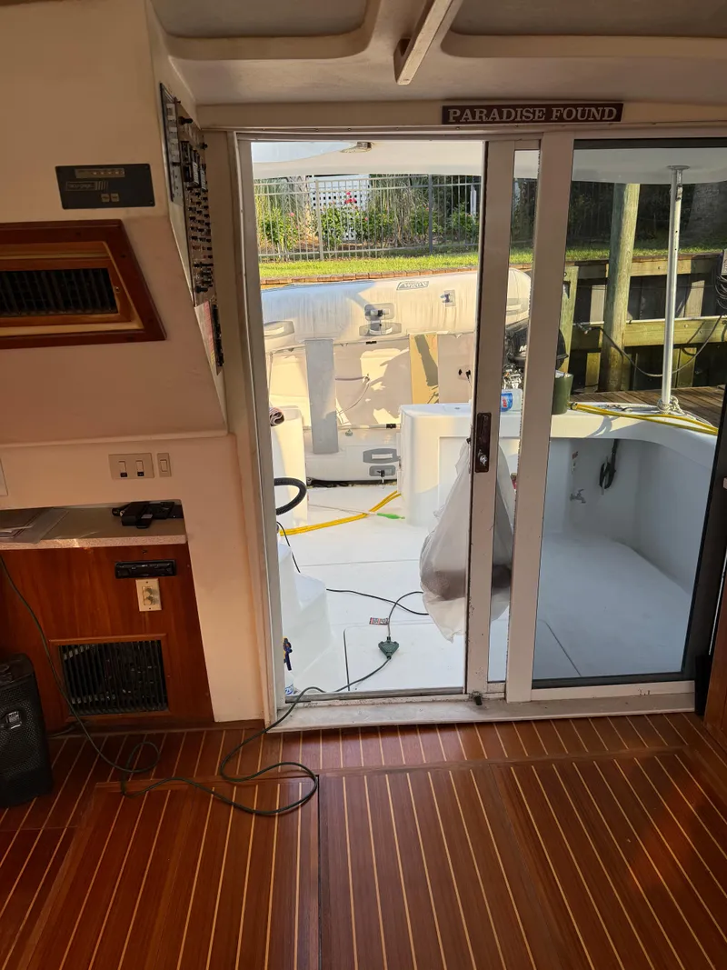 Slide: The Image of Interior view of 2000 Mainship 390 Trawler with wooden flooring and sliding glass door. - 8