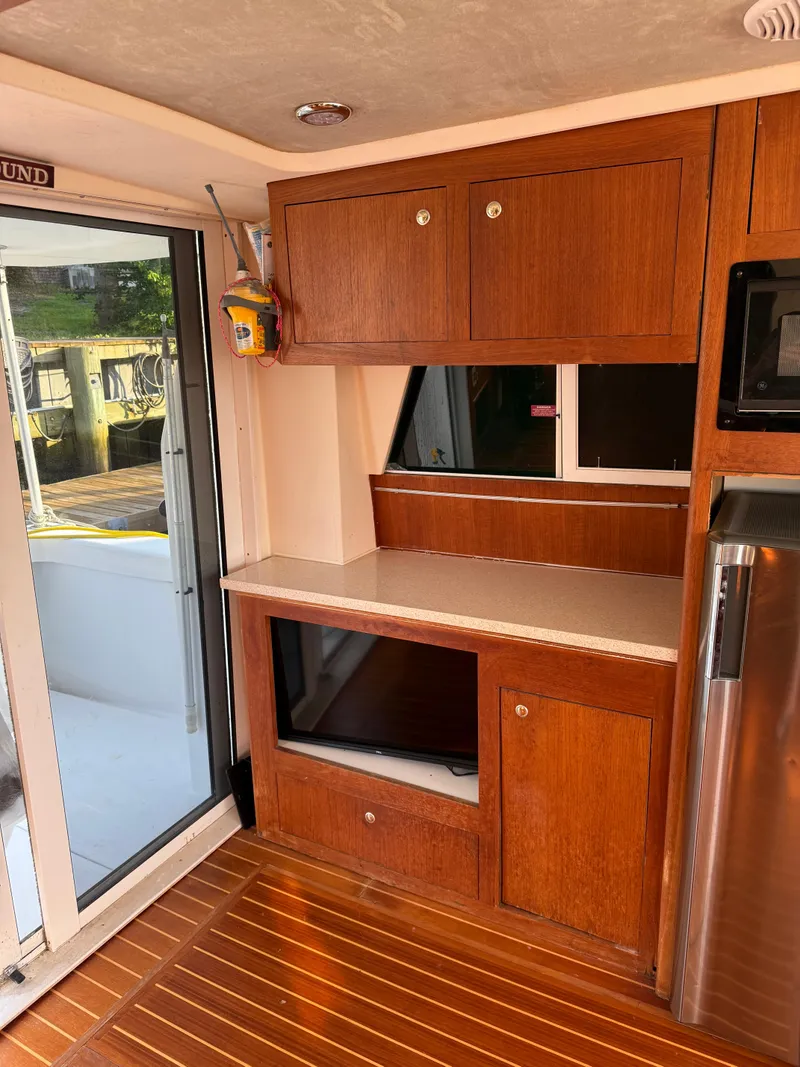Slide: The Image of Interior of 2000 Mainship 390 Trawler with wooden cabinets and modern appliances. - 9
