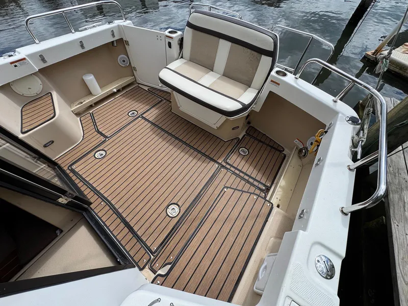 Slide: The Image of 2016 Cutwater C-26 boat interior with cushioned seating and wood-patterned flooring. - 11