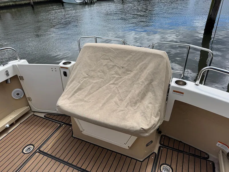 Slide: The Image of 2016 Cutwater C-26 boat deck with covered seating, docked by the water. - 13