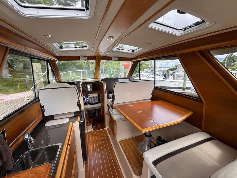Slide: The Image of Interior of a 2016 Cutwater C-26 boat with wood accents and seating area. - 14
