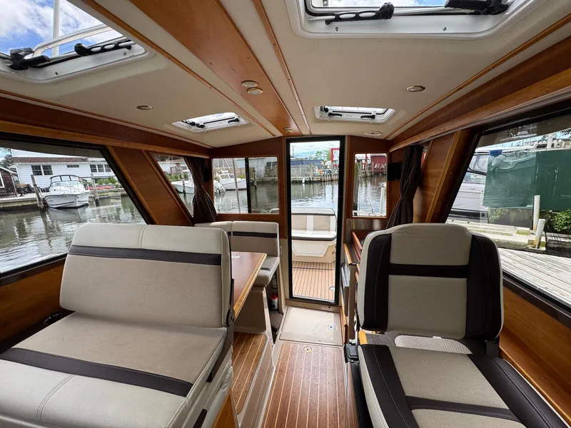 Slide: The Image of Interior of 2016 Cutwater C-26 boat with seating and windows overlooking marina. - 15