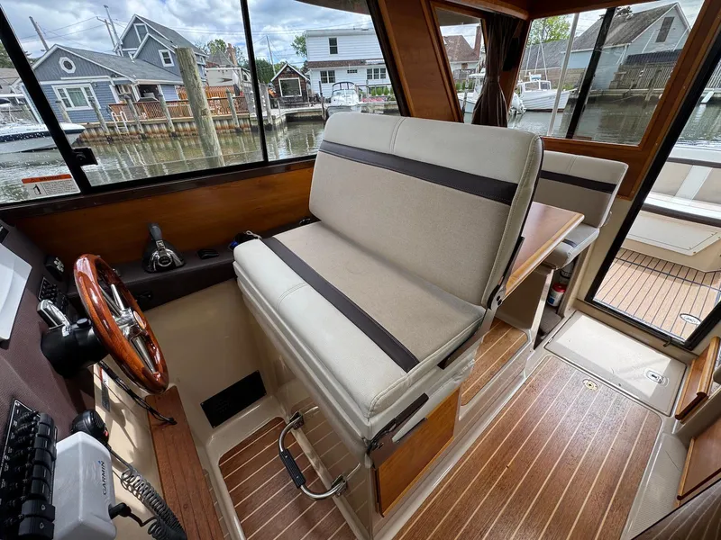 Slide: The Image of Interior of a 2016 Cutwater C-26 boat with helm seat and wooden flooring. - 16