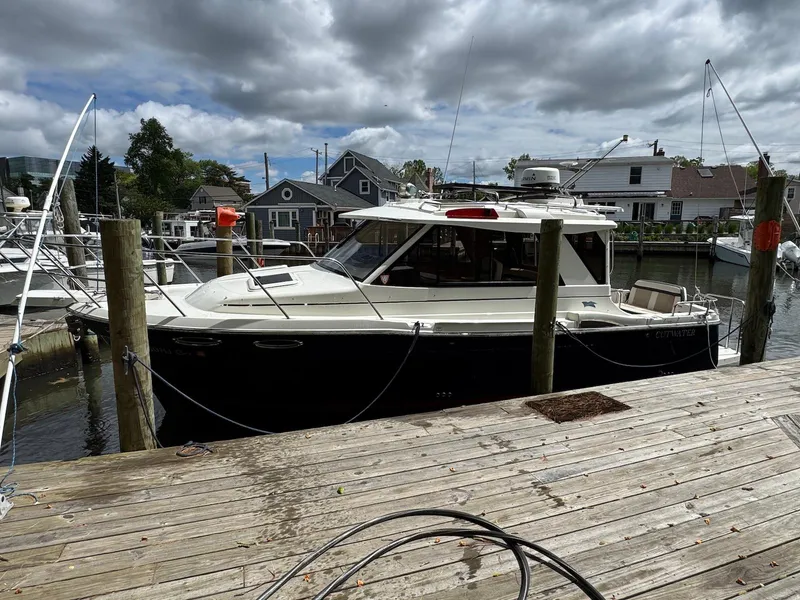 Slide: The Image of 2016 Cutwater C-26 boat docked at a marina under cloudy skies. - 2