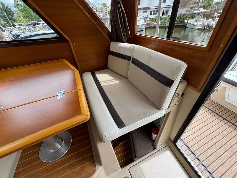 Slide: The Image of Interior of 2016 Cutwater C-26 boat with seating and wooden table. - 20