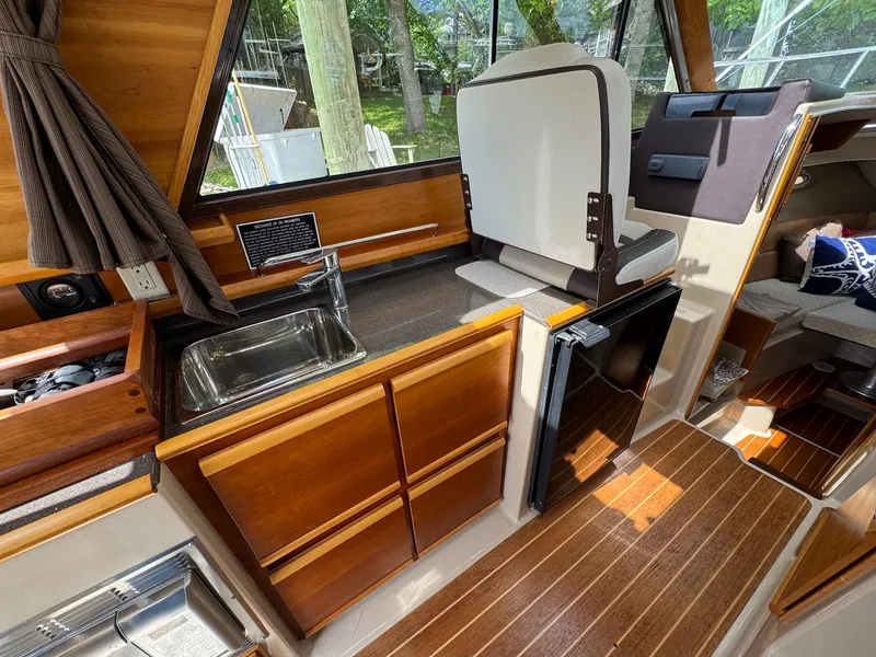 Slide: The Image of Interior of 2016 Cutwater C-26 boat with wooden cabinetry and compact kitchen area. - 22