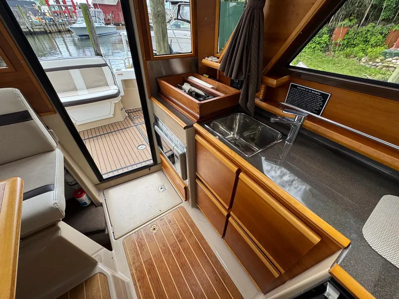 Slide: The Image of Interior of a 2016 Cutwater C-26 boat featuring a compact kitchen area. - 24