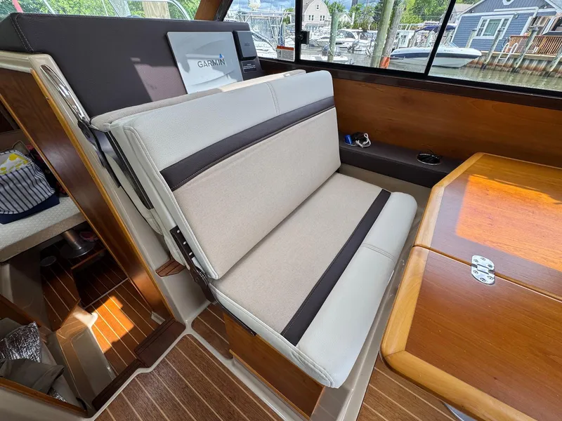 Slide: The Image of Interior of 2016 Cutwater C-26 boat with beige seating and wooden table. - 27