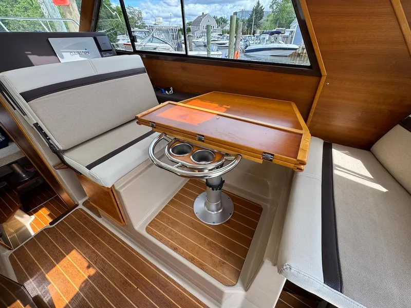 Slide: The Image of 2016 Cutwater C-26 interior with wooden table and cushioned seating. - 31