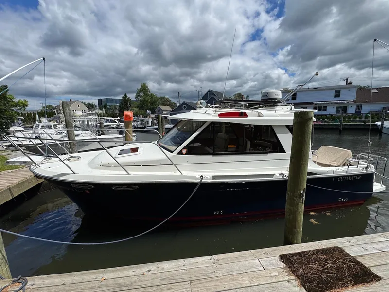 Slide: The Image of 2016 Cutwater C-26 boat docked at a marina under a cloudy sky. - 4