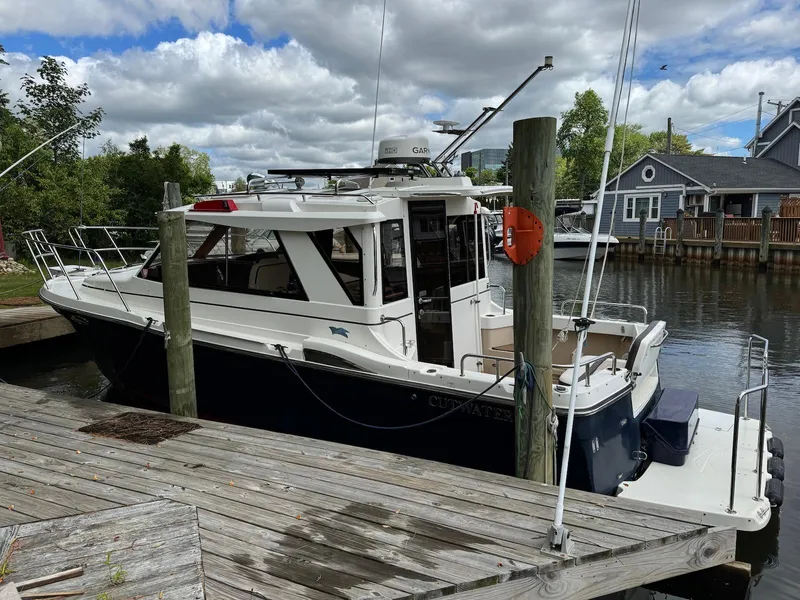 Slide: The Image of 2016 Cutwater C-26 boat docked by a wooden pier under a cloudy sky. - 7