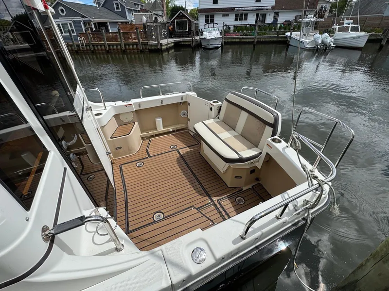 Slide: The Image of 2016 Cutwater C-26 boat with spacious deck and seating, docked by waterfront homes. - 8