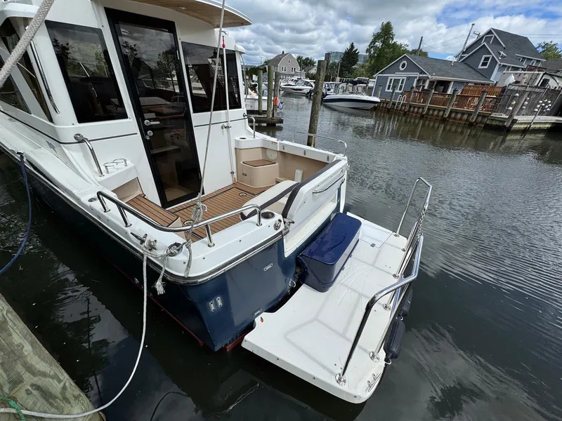 Slide: The Image of 2016 Cutwater C-26 boat docked in a marina, featuring a spacious deck and modern design. - 9