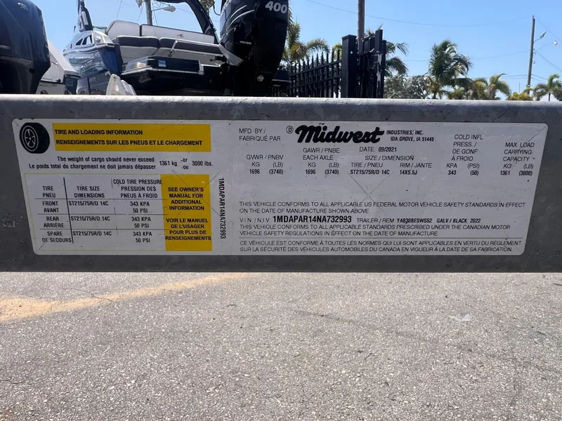 Slide: The Image of Label on a 2022 Midwest Trailer 19, displaying tire and loading information. - 12