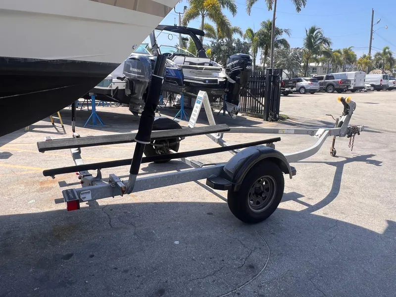 Slide: The Image of 2022 Trailer 19 with boat, parked outdoors near palm trees. - 4