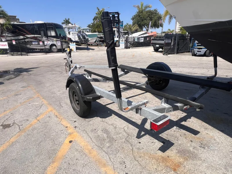 Slide: The Image of Boat trailer parked in a lot, 2022 model, with surrounding vehicles and palm trees. - 5