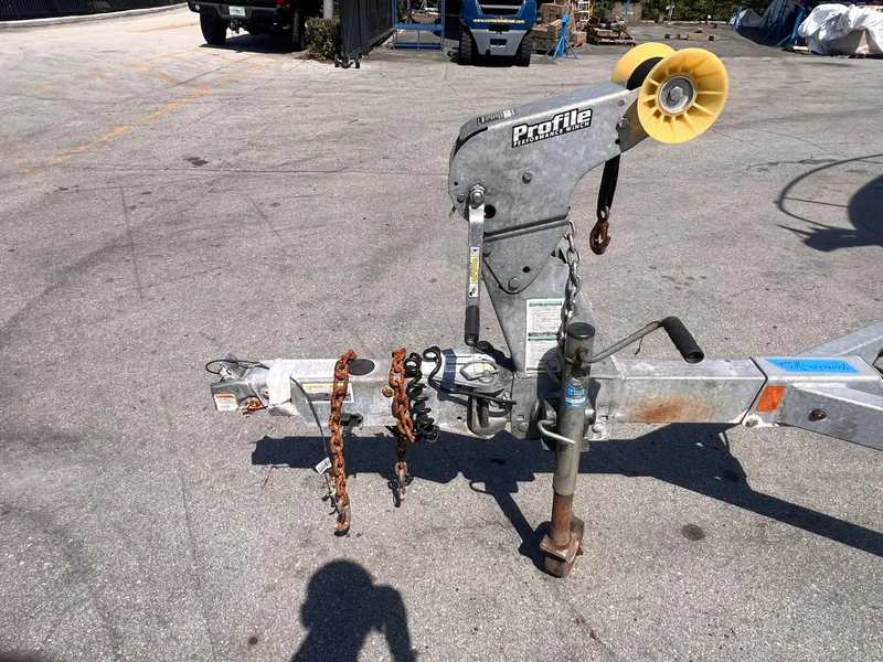 Slide: The Image of Trailer hitch with chains and wheel, 2022 model, parked on asphalt. - 7