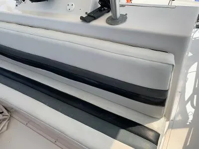 Slide: The Image of 1989 Trojan 12 Meter Convertible boat seating with white and black cushions. - 19