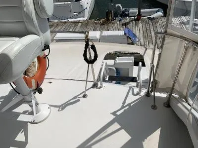 Slide: The Image of 1989 Trojan 12 Meter Convertible boat interior with white seating and dock view. - 21