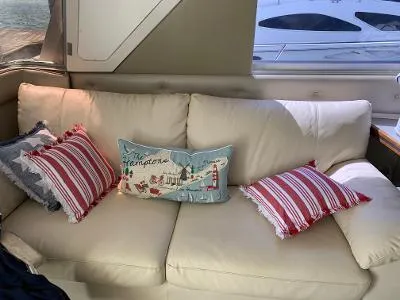 Slide: The Image of Beige sofa with decorative pillows inside a 1989 Trojan 12 Meter Convertible boat. - 26