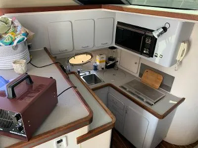 Slide: The Image of 1989 Trojan 12 Meter Convertible yacht kitchen with microwave, sink, and storage cabinets. - 28