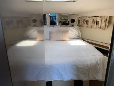 Slide: The Image of 1989 Trojan 12 Meter Convertible yacht bedroom with cozy bed and nautical decor. - 29