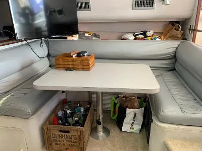 Slide: The Image of 1989 Trojan 12 Meter Convertible interior with dining area, table, and storage. - 32