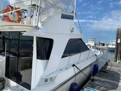 Slide: The Image of 1989 Trojan 12 Meter Convertible yacht docked at marina under blue sky. - 6