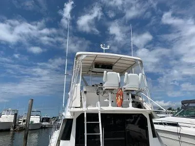 Slide: The Image of 1989 Trojan 12 Meter Convertible yacht docked under a blue sky. - 24
