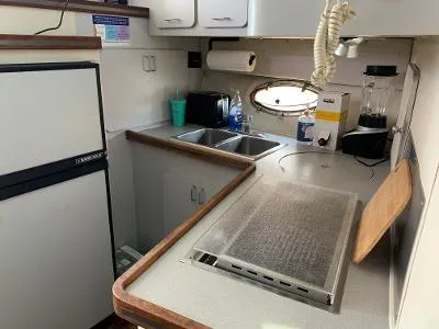 Slide: The Image of 1989 Trojan 12 Meter Convertible yacht kitchen with stove, sink, and refrigerator. - 31