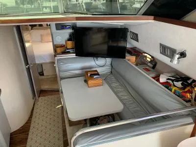 Slide: The Image of Interior of 1989 Trojan 12 Meter Convertible yacht with seating, table, and mounted TV. - 37