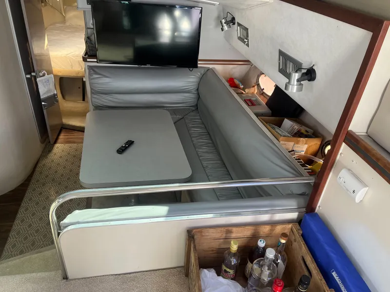 Slide: The Image of 1989 Trojan 12 Meter Convertible interior with seating, table, TV, and beverage storage. - 42
