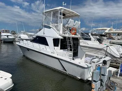 Slide: The Image of 1989 Trojan 12 Meter Convertible yacht docked at marina under blue sky. - 8
