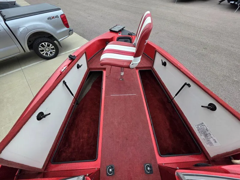 Slide: The Image of Red 1997 Ranger 692 boat interior with storage compartments and a striped seat. - 10