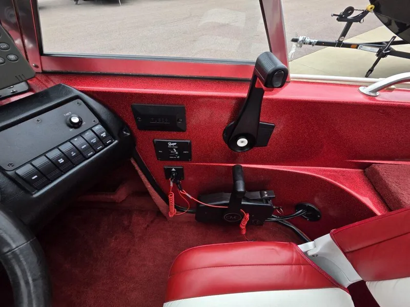 Slide: The Image of Interior of a 1997 Ranger 692 boat, featuring red and white seating and control panel. - 18