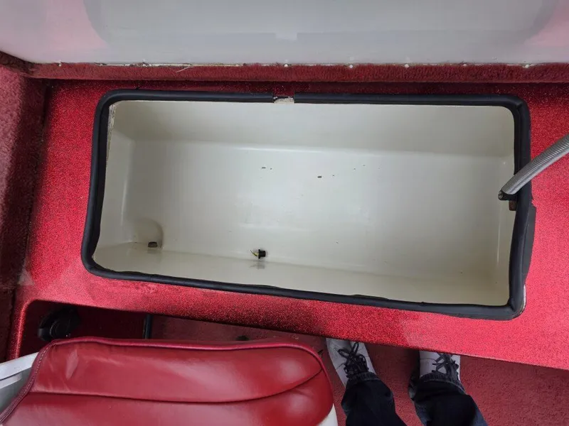 Slide: The Image of 1997 Ranger 692 boat storage compartment with red interior and open lid. - 21