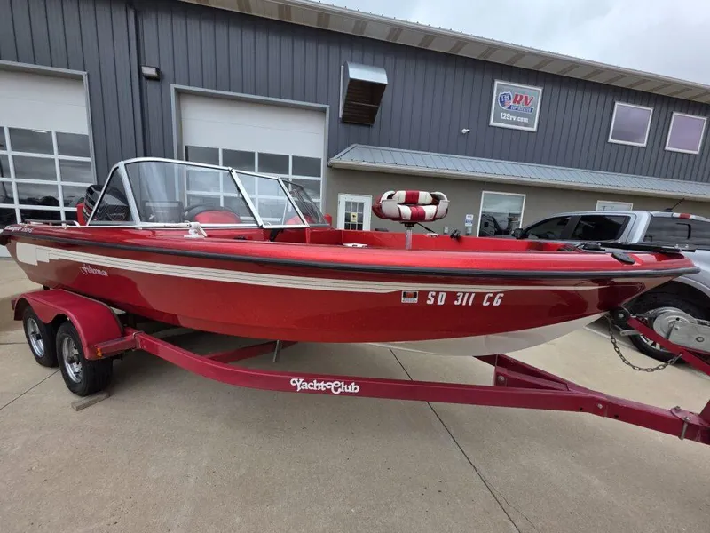 Slide: The Image of Red 1997 Ranger 692 boat on trailer, parked outside a building. - 3