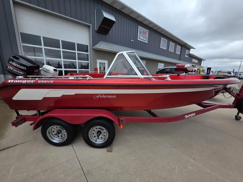 Slide: The Image of Red 1997 Ranger 692 boat on trailer, parked outside a garage. - 4