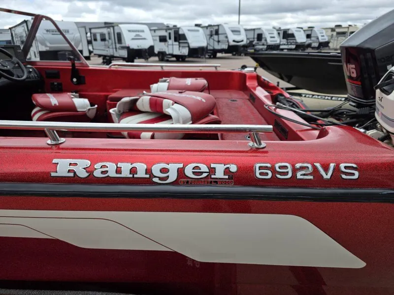 Slide: The Image of Red 1997 Ranger 692VS boat with white interior, parked near RVs. - 8