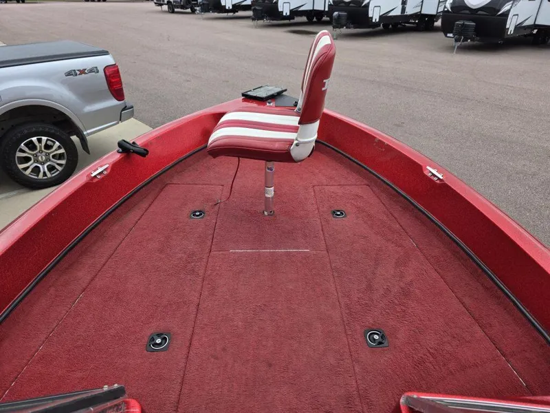 Slide: The Image of Red 1997 Ranger 692 boat deck with striped seat, parked near vehicles. - 9