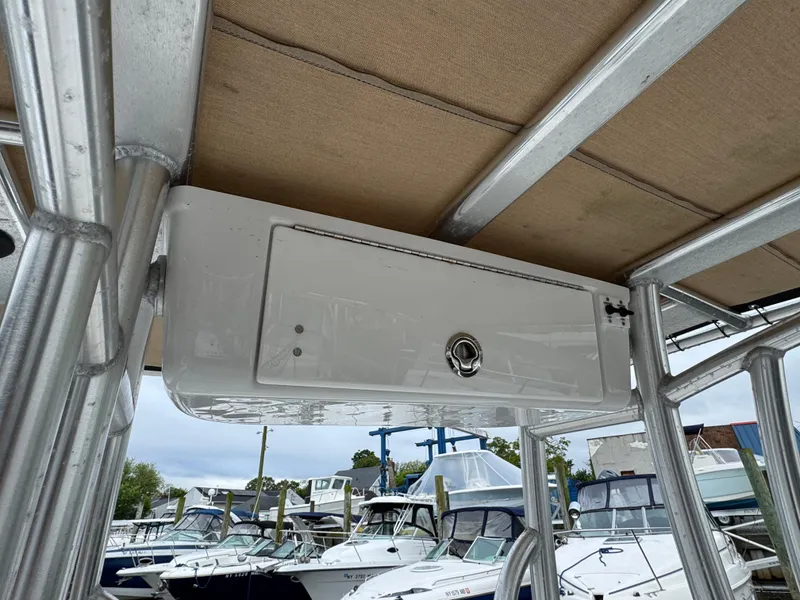 Slide: The Image of 2020 Tidewater 198 CC Adventure boat with overhead storage compartment in marina setting. - 10